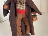 a figurine of an old man with a hat and a cane