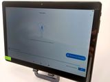 the tablet is sitting on a stand with a phone on top of it