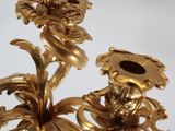 an image of a gold colored candle holder with two flowers on it