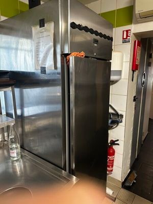 un réfrigérateur en acier inoxydable dans une cuisine équipée d'un plan de travail
