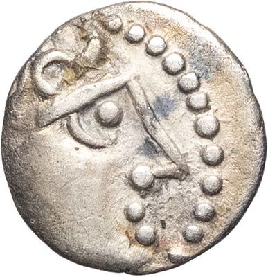 a silver coin with an image of a face on it