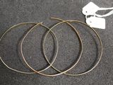 un gros plan sur trois boucles d'oreilles en anneau dorées posées sur une table