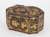 une boîte ancienne en bois ornée de motifs dorés et noirs