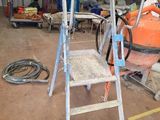 une photo d'une échelle dans un garage, à côté d'autres outils
