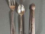 three spoons, a fork, and a spoon on a table