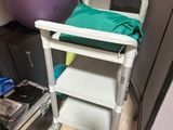 a white cart with a green towel on it in a room