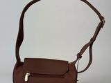 a brown leather purse with a gold clasp on the handle