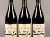 trois bouteilles de vin sont alignées sur une table
