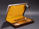 a wooden box with silverware in it on a gray surface