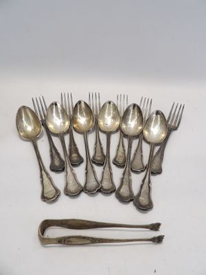 de nombreuses cuillères et fourchettes en argent posées sur une table