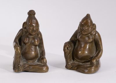 pair of bronze figurines of a seated man and a seated woman