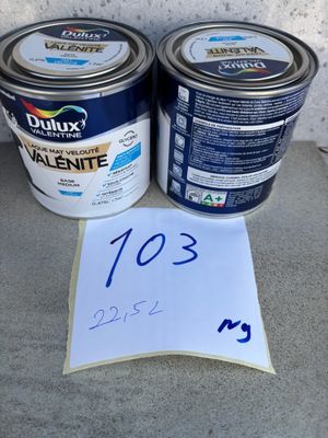 deux pots de peinture et une feuille de papier posés par terre