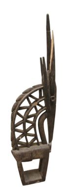 une sculpture en bois représentant une chaise sur laquelle est perché un oiseau
