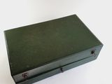 a green suitcase sitting on top of a white table