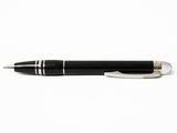 le stylo est noir avec des finitions argentées et repose sur une surface blanche