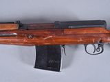an old wooden rifle with a magazine attached to it ' s side