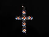 un pendentif en forme de croix bleue et rouge sur fond noir