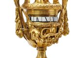 a gold vase with a clock on top of it