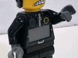 a lego man that is holding a gun in his hand