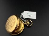 un gros plan d'un porte-clés en forme de pièce d'or muni d'une étiquette