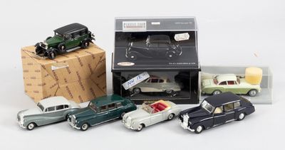 Plusieurs petites voitures sont rangées dans une boîte, à côté d'une pile de boîtes.