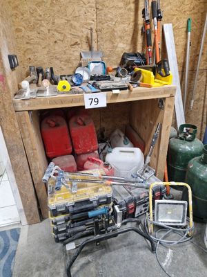 de nombreux outils posés sur une étagère dans un garage