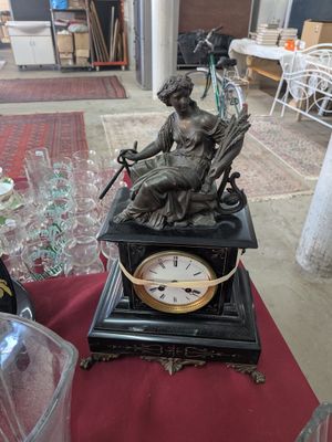 a statue of a woman sitting on top of a clock