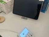 un bureau sur lequel se trouvent un écran, un téléphone et d'autres objets