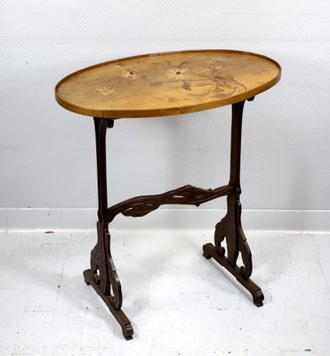 une table ancienne avec un plateau en bois et des pieds en métal