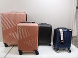 trois bagages posés sur une étagère blanche