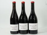 trois bouteilles de vin rouge sont alignées sur une surface blanche