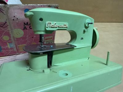 a green sewing machine sitting on top of a table