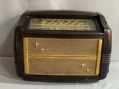 une vieille radio posée sur une table près d'un mur blanc