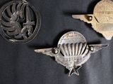 three old metal badges on a black cloth with a black background