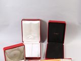 three open boxes with a ring inside of them on a white surface