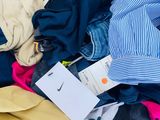a pile of clothes on a bed with a tag on it