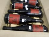 six bottles of wine are in a cardboard box on a table
