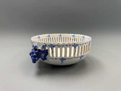 petit bol bleu et blanc orné d'un motif floral sur le côté