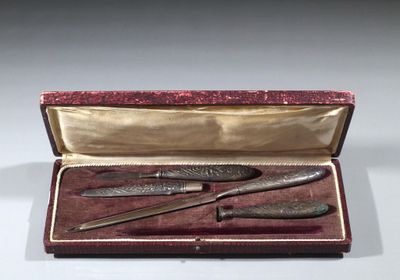 deux pièces d'argenterie dans un coffret rouge posé sur une surface blanche