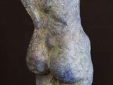 a close up of a sculpture on a wooden stand on a black background
