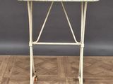 une vieille table blanche à roulettes posée sur un parquet