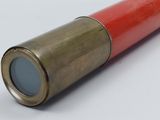 a red and gold telescope on a white surface