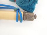 a blue yarn and a wooden stick on a white surface