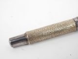 a close up of a pen on a table with a white background