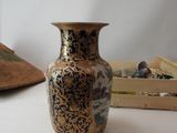 a vase that is sitting on a table next to a hat