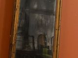 a mirror hanging on the wall next to a toilet