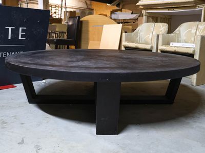 a black coffee table sitting in a warehouse area