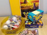 a box of pokemon cards, a box of cards, and a box of cards on a table