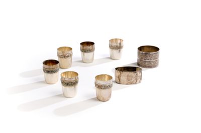 six coupes en argent sont disposées en cercle sur une surface blanche