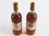 two bottles of alcohol sitting next to each other on a white surface